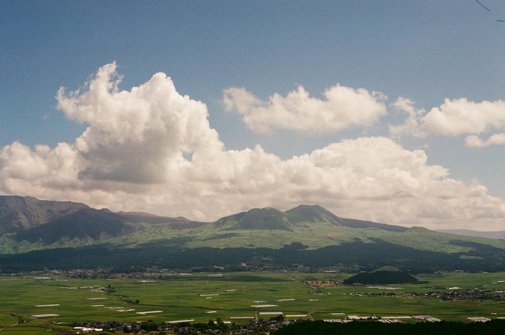雲の下に広がる阿蘇の山々と田園