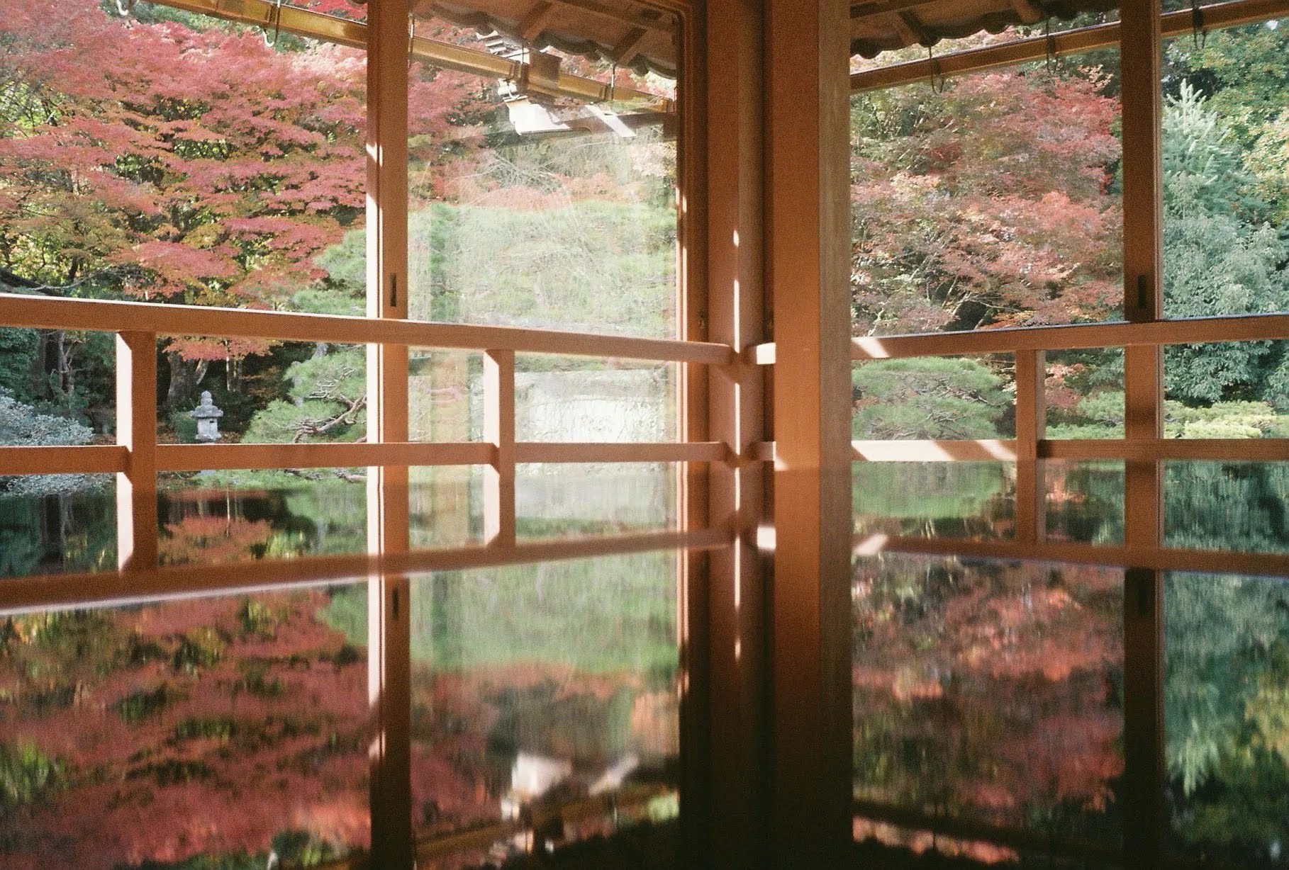 旧竹林院の座敷の机に映り込む紅葉の庭園