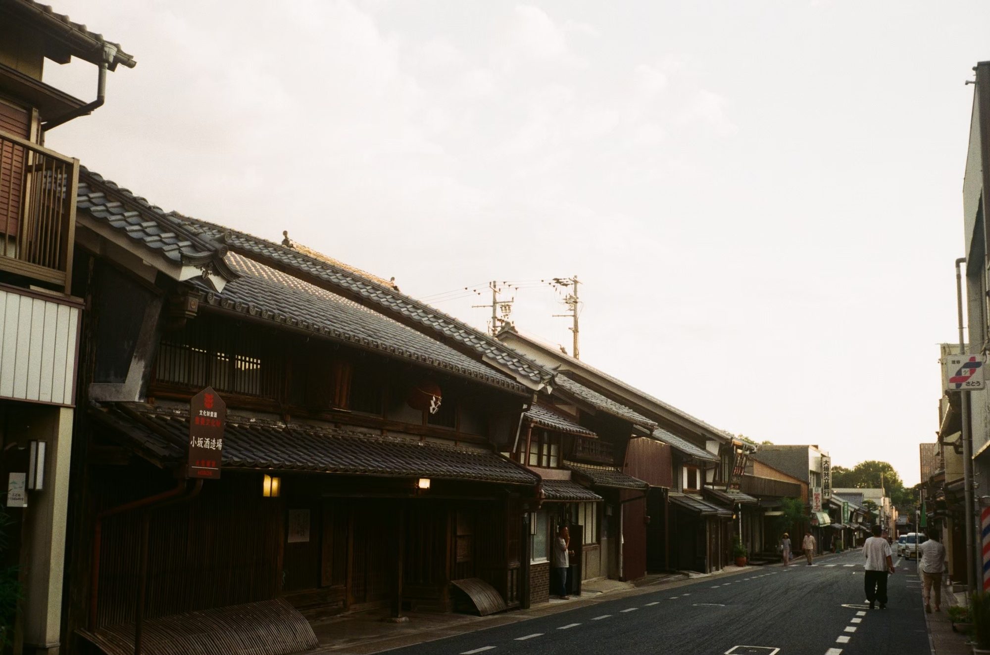 夕方の光に照らされる、卯建の上がる古い町並みの通り