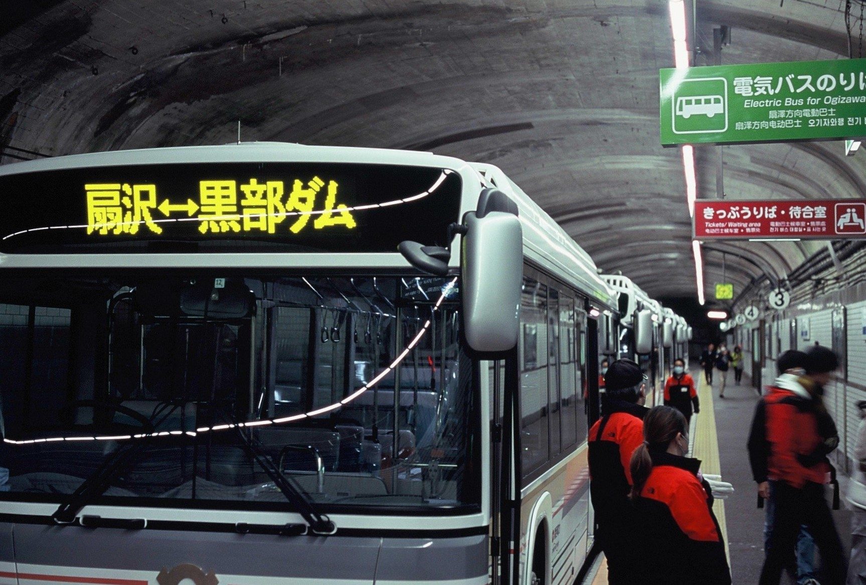 トンネル内の駅に停車する「扇沢⇔黒部ダム」の電気バス